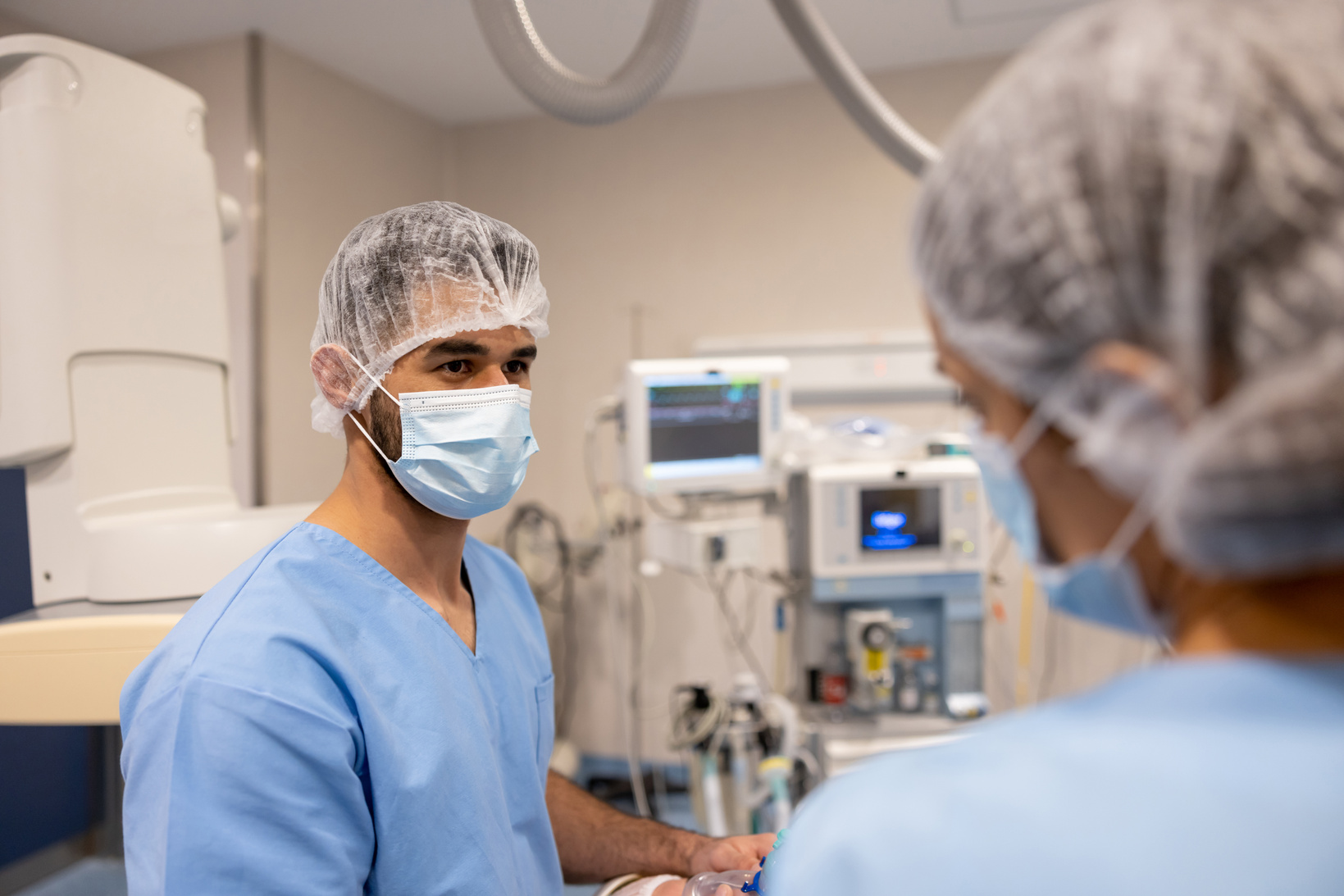 Surgeons talking in the hemodynamics room while performing a medical procedure